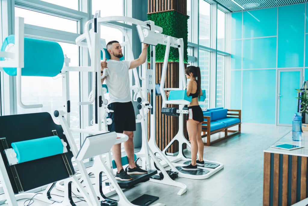 Sportspeople in activewear exercising on gym equipment